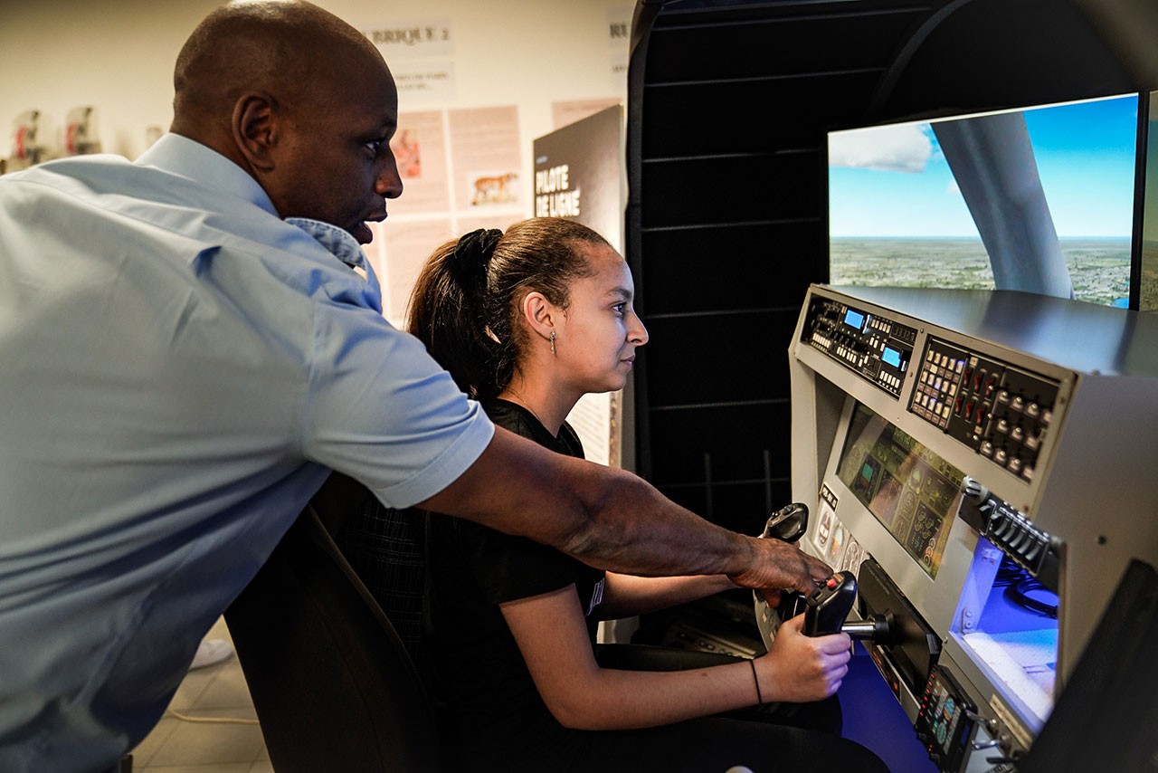 eune fille apprenant à piloter un simulateur de vol avec un instructeur