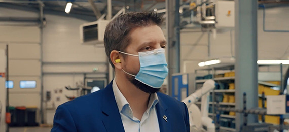 Employee in a face mask with ear protection in